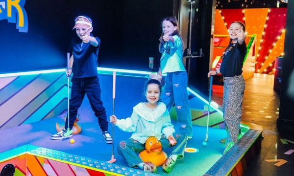 Kids playing mini golf on a rainy day